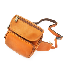 Load image into Gallery viewer, DayTrekr Leather Hip Pack - Tan
Image of Left-Facing Angled View with adjustable leather waist strap. Back side of leather waist strap is reinforced with webbed nylon for added strength.
Dimensions: 7" H x 6.5" W x 2.5"