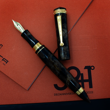 Load image into Gallery viewer, The fountain pen with the cap next to it. Set on top of the outer box and red booklet.