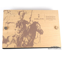 Load image into Gallery viewer, Top view of the presentation box with a printed illutration of Don Quijote de la Mancha riding his horse and the Delta Logo.