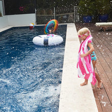 Load image into Gallery viewer, A small child wearing pink goggles stands in front of a pool with a pink and white stripes towel.