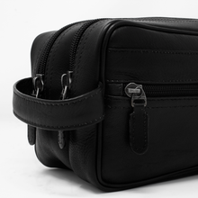 Load image into Gallery viewer, Dorado Double Pocket Shave Kit - Black
Left Facing Front Panel Closeup View, showing matching leather handle grip, two top zip main compartments, and front panel zip accessory pockets. All exterior zippers feature matching leather zipper tabs.
DIMENSIONS: 10.5(L) X 5.5(H) X 5"(D)