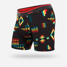 Load image into Gallery viewer, Angled view of the boxer brief on a white background. It is made with black fabric and a pattern of different shaped and colored figures.