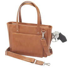 Load image into Gallery viewer, Angled front view of the tan leather concealed carry purse with a gun peeking from the compartment.