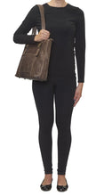 Load image into Gallery viewer, A young woman carrying the brown leather concealed carry purse.