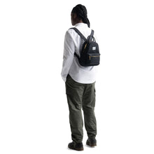 Load image into Gallery viewer, Angled back view of a model carrying the black Herschel Nova Mini backpack.