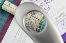 Load image into Gallery viewer, Close up to the artist signature Volovik with the magnifying glass.