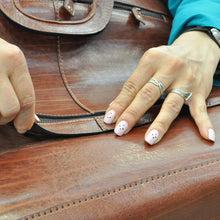 Load image into Gallery viewer, Close up on a pair of hands building a brown satchel bag.