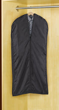 Load image into Gallery viewer, A suit in a closet tucked inside the garment cover.