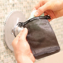 Load image into Gallery viewer, A pair of hands pulling the soap bar from the bag.