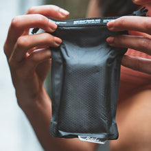 Load image into Gallery viewer, A pair of hands holding the travel bag with a soap bar inside.