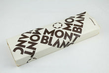 Load image into Gallery viewer, Angled view of the outer white sleeve with angled prints of the Montblanc logo. It shows signs of age and deterioration.