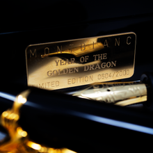 Load image into Gallery viewer, Close up to the presentation box's front plate with engraved text: MONTBLANC, YEAR OF THE GOLDEN DRAGON, LIMITED EDITION 0604 OF 2000