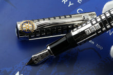 Load image into Gallery viewer, Close up to the pen's grip section with the cap next to it on a blue background.