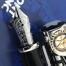Load image into Gallery viewer, Close up to the nib with complex engraved decorations next to the cap with Rotary International emblem on top of the clip.