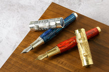 Load image into Gallery viewer, The fountain pens in vermeil red, and silver gold on a wooden surface.