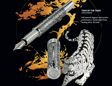 Load image into Gallery viewer, The fountain pen and cap arranged on a graphic with a tiger, a tree, and text.