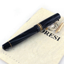 Load image into Gallery viewer, Side view of the fountain pen arranged with the booklet and extra nib on a white background.