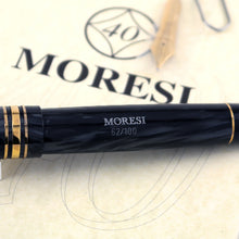 Load image into Gallery viewer, Close up to the fountain pen barrel, featuring the engraved Moresi logo and edition number 62 of 100