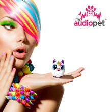 Load image into Gallery viewer, A young woman dressed in vibrant colors holding the unicorn speaker on her hand's palm.