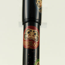 Load image into Gallery viewer, Close up to the red Daruma doll on the pen barrel.