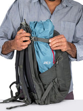 Load image into Gallery viewer, A man tightening the side panel's adjustable strap on the backpack.