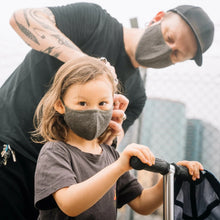 Load image into Gallery viewer, A man wearing a mask adjusting the face mask on a child.