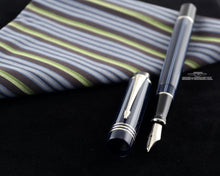 Load image into Gallery viewer, Angled view of the fountain pen with the cap set next to it.