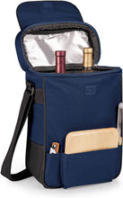 Load image into Gallery viewer, Angled front view of the blue cooler tote bag with two wine bottles, a cutting board and knives arranged in the compartments.