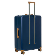 Load image into Gallery viewer, Angled back view of the blue suitcase on a white background. The telescopic handle is pulled up.