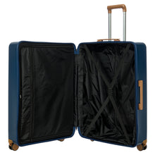 Load image into Gallery viewer, View of the blue suitcase opened on a white background. The left side features a zipper-closing compartment, and the right side has a set of straps to hold items in place.