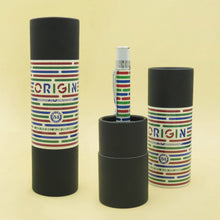 Load image into Gallery viewer, The Origin pen arranged with two matching pen gift tubes on a pastel yellow background