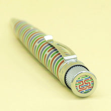 Load image into Gallery viewer, Angled top view of the pen. The top disk features green, blue, and red design with lines. The number 25 is drawn at the center.