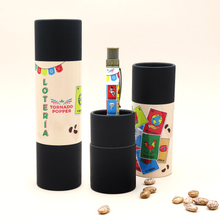 Load image into Gallery viewer, The rollerball pen arranged on a white background with a grouping of pinto beans, and the presentation gift tubes.