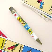 Load image into Gallery viewer, Angled view of the loteria pen with arranged cards on the background.