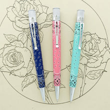 Load image into Gallery viewer, Front views of a navy blue, pink, and aqua set of pens on a background with illustrated roses.