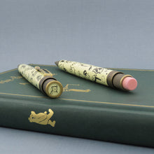 Load image into Gallery viewer, Angled top views of the pen and pencil atop a green hardcover book.