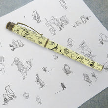 Load image into Gallery viewer, Side view of the Decorations fountain pen on a printed page with EH Shepard illustrations.