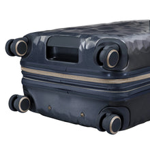 Load image into Gallery viewer, Angled bottom close up to the navy blue suitcase. It features four spinner wheels and a grab handle.