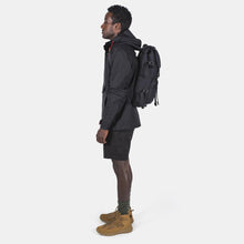 Load image into Gallery viewer, Side View with a young man carrying the black backpack.