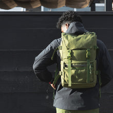 Load image into Gallery viewer, Front panel view of the backpack being carried by a young man.