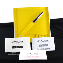 Load image into Gallery viewer, The ballpoint pen on its yellow display with the booklets.