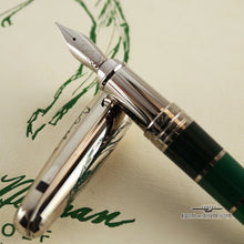 Load image into Gallery viewer, Close up of the fountain pen nib and grip section resting on the cap.