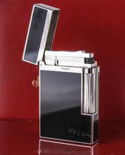 Load image into Gallery viewer, Angled front view of the lighter with the lid lifted, arranged with the red packaging.