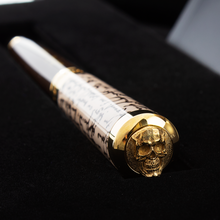 Load image into Gallery viewer, Angled top view of the cap. It features a detailed raised engraving of a skull.