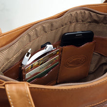 Load image into Gallery viewer, Interior view of the leather tote bag with a set of credit cards, a charging cable, and a phone tucked into the compartments.