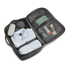 Load image into Gallery viewer, Interior view with clothes and travel accessories organized in the compartments.
