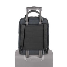 Load image into Gallery viewer, Back panel view of the backpack  with the attachment strap holding on to the handle of a suitcase.