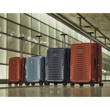 Load image into Gallery viewer, Group shot showing the carry-on sizes in red and light blue, and the larger sizes in navy blue and orange .