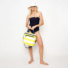 Load image into Gallery viewer, Front view of the cooler bag being held by a model wearing a black swimsuit and a white sun hat. Set on a white background.
