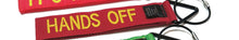 Load image into Gallery viewer, Red luggage tag with yellow embroidered text: HANDS OFF